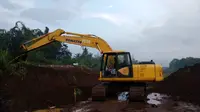 Alat berat Jasa Marga Malang - Pandaan membersihkan tebing di lokasi penemuan situs pra Majapahit (Liputan6.com/Zainul Arifin)