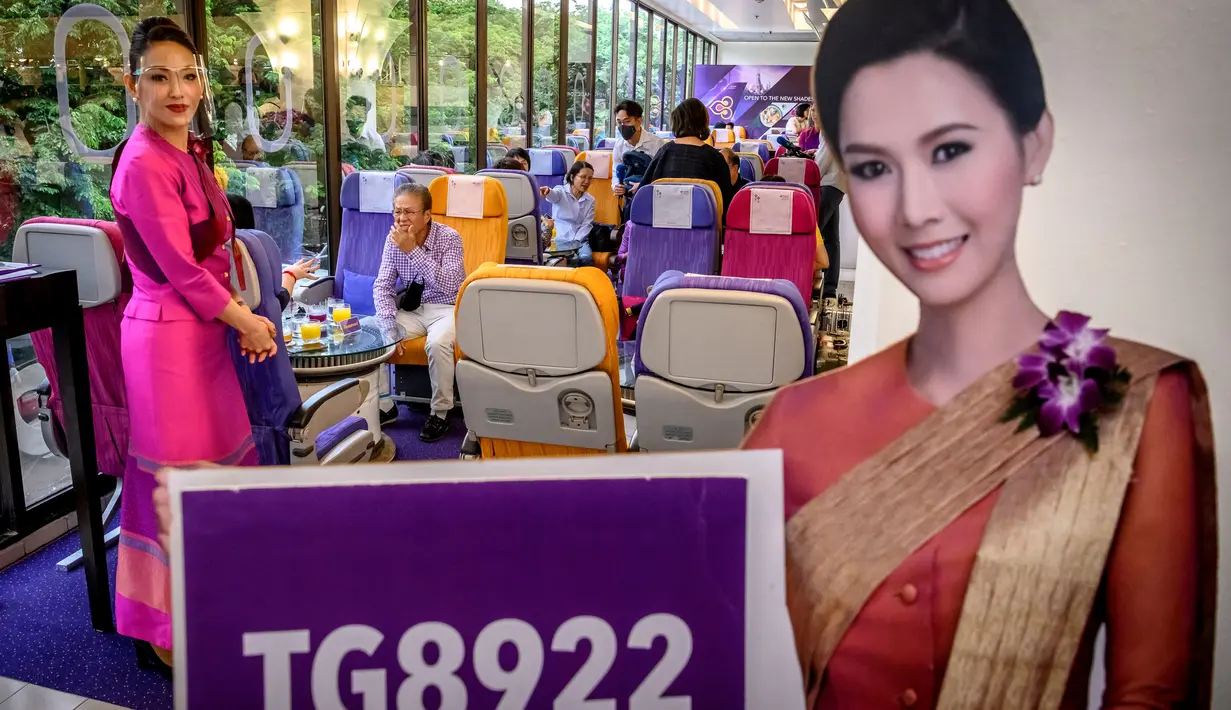 Seorang pramugari mengenakan pelindung wajah di restoran pop-up bertema kabin pesawat di kantor pusat Thai Airways di Bangkok, 10 September 2020. Rencananya, kantor Thai Airways lainnya akan diubah menjadi restoran bertema kabin pesawat untuk memberi pengalaman bersantap serupa. (Mladen ANTONOV/AFP)