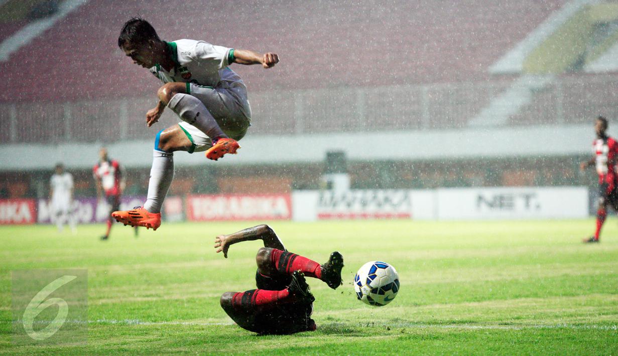 Pemain Persipura Ferinando Pahabol (bawah) berusaha mengambil bola dari pemain Surabaya United, M.Faturahman saat laga 8 besar Piala Jenderal Sudirman di Stadion Maguwoharjo, Sleman, Selasa (22/12/2015). Persipura menang 2-0. (Foto: Boy Harjanto)