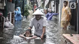 Aktivitas warga saat banjir merendam permukiman di Bukit Duri, Jakarta, Kamis (18/2/2021). Hujan deras yang mengguyur sejak pagi menyebabkan permukiman warga di 5 RW, yakni RW 03, 04, 05, 06, dan 07 Kelurahan Bukit Duri terendam banjir. (merdeka.com/Iqbal S Nugroho)