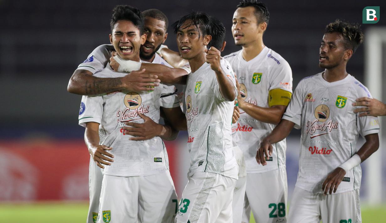 Pemain muda Persebaya Surabaya, Marselino Ferdinan, dipeluk oleh rekan-rekan setimnya setelah mencetak gol yang berhasil menyelamatkan Bajul Ijo dari kekalahan saat menghadapi Arema FC pada laga pekan ke-11 BRI Liga 1 2021/2022, Sabtu (6/11/2021). (Bola.com/Bagaskara Lazuardi)