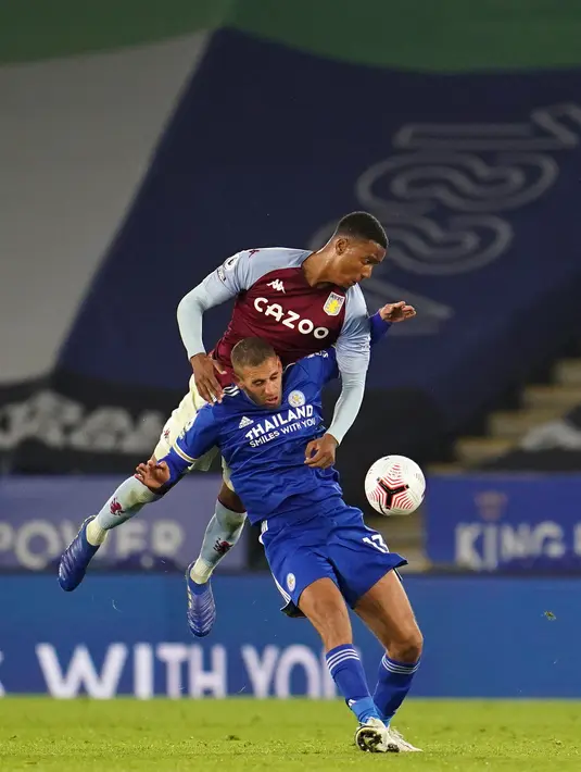 Bek Aston Villa, Ezri Konsa melompat di atas striker Leicester City, Islam Slimani saat berebut bola dalam lanjutan Liga Inggris, di Stadion King Power, Senin (19/10/2020). Aston Villa berhasil menang atas Leicester City berkat gol semata wayang Ross Barkley di menit injury time. (Jon Super / POOL /