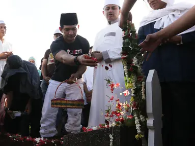  Aktor Iko Uwais menaburkan bunga di pemakaman ayahnya Musthafa Kamaluddin di TPU Prumpung, Jakarta, Rabu (8/3). Ayah Iko Uwais wafat pada  Rabu (8/3/2017) pagi di RSCM. (Liputan6.com/Herman Zakharia)