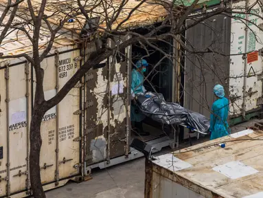 Pekerja memindahkan jenazah dari truk ke kontainer berpendingin di Rumah Sakit Umum Fu Shan, Hong Kong, Rabu (16/3/2022). Kasus COVID-19 terburuk yang melanda Hong Kong menimbulkan kepanikan serta membuat rumah sakit dan kamar jenazah penuh. (DALE DE LA REY/AFP)