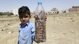 Seorang anak menunjukkan botol berisi belalang gurun di Sanaa, Yaman (9/10/2020). Kawanan belalang gurun menyerbu Sanaa, ibu kota Yaman, pada Jumat (9/10). (Xinhua/Mohammed Mohammed)