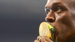  Sprinter Jamaika, Usain Bolt, mencium medali emas lari 100 m Olimpiade Rio 2016 yang diraihnya dalam final di Olympic Stadium, Rio de Janeiro, Brasil, (15/8/2016). (Reuters/Leonhard Foeger)