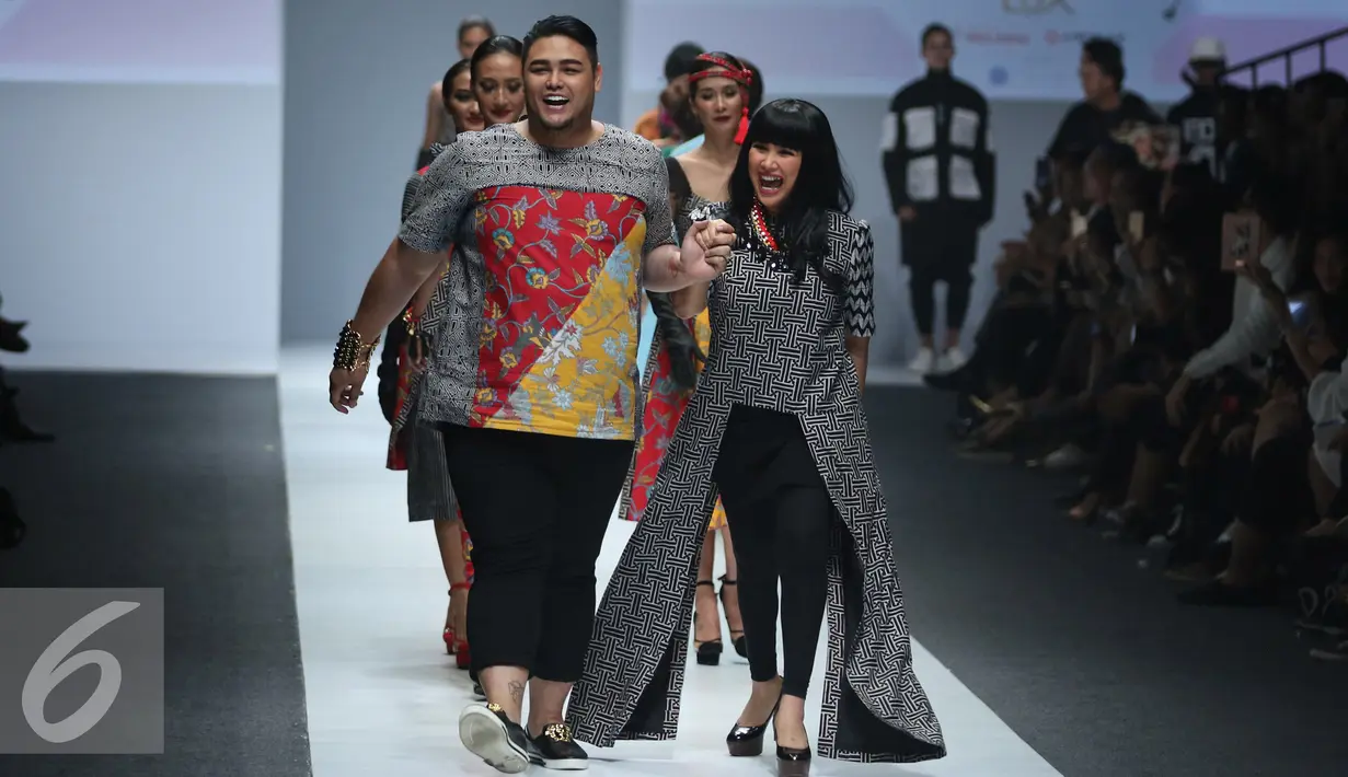 Desainer Ivan Gunawan bersama penyanyi Titi DJ berjalan saat membawakan busana bertema lembayoeng di Jakarta Fashion Week (JFW) 2016, Jakarta Fashion Week (JFW) 2016, Senayan city, Jakarta, (25/10/2015). (Liputan6.com/Herman Zakharia)