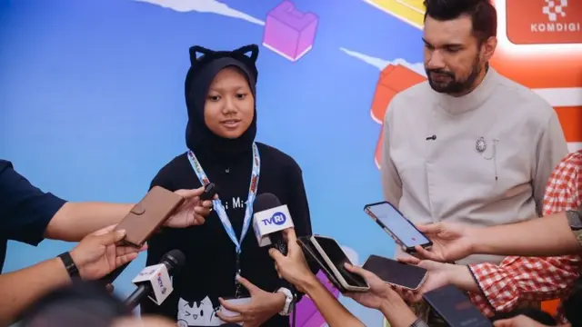 Pengembang game muda Adelia Misha didampingi Presiden Asosiasi Game Indonesia (AGI) Shafiq Husein memberikan keterangan kepada awak media usai acara Indonesia Game Developer eXchange (IGDX) Conference 2025 di The Stones Hotel, Bali. Foto: Komdigi