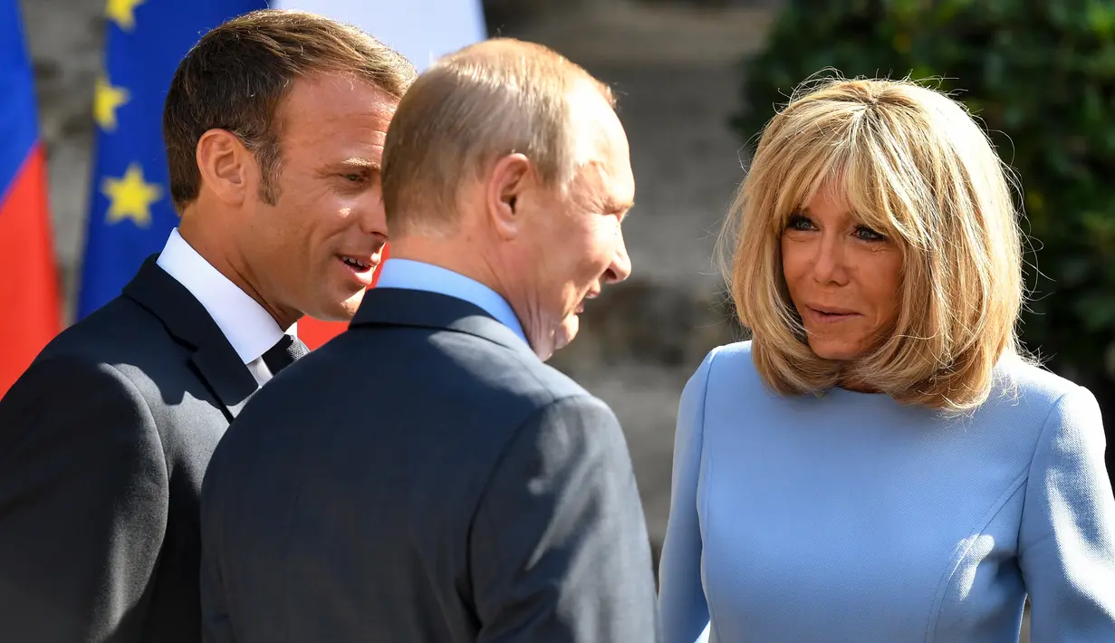 Presiden Prancis Emmanuel Macron (kiri) dan istrinya Brigitte Macron (kanan) menyambut Presiden Rusia Vladimir Putin (tengah) di Benteng Bregancon, Bormes-les-Mimosas, Prancis, Senin (19/8/2019). Macron dan Putin mencoba meningkatkan hubungan Uni Eropa dengan Moskow. (Gerard JULIEN/POOL/AFP)