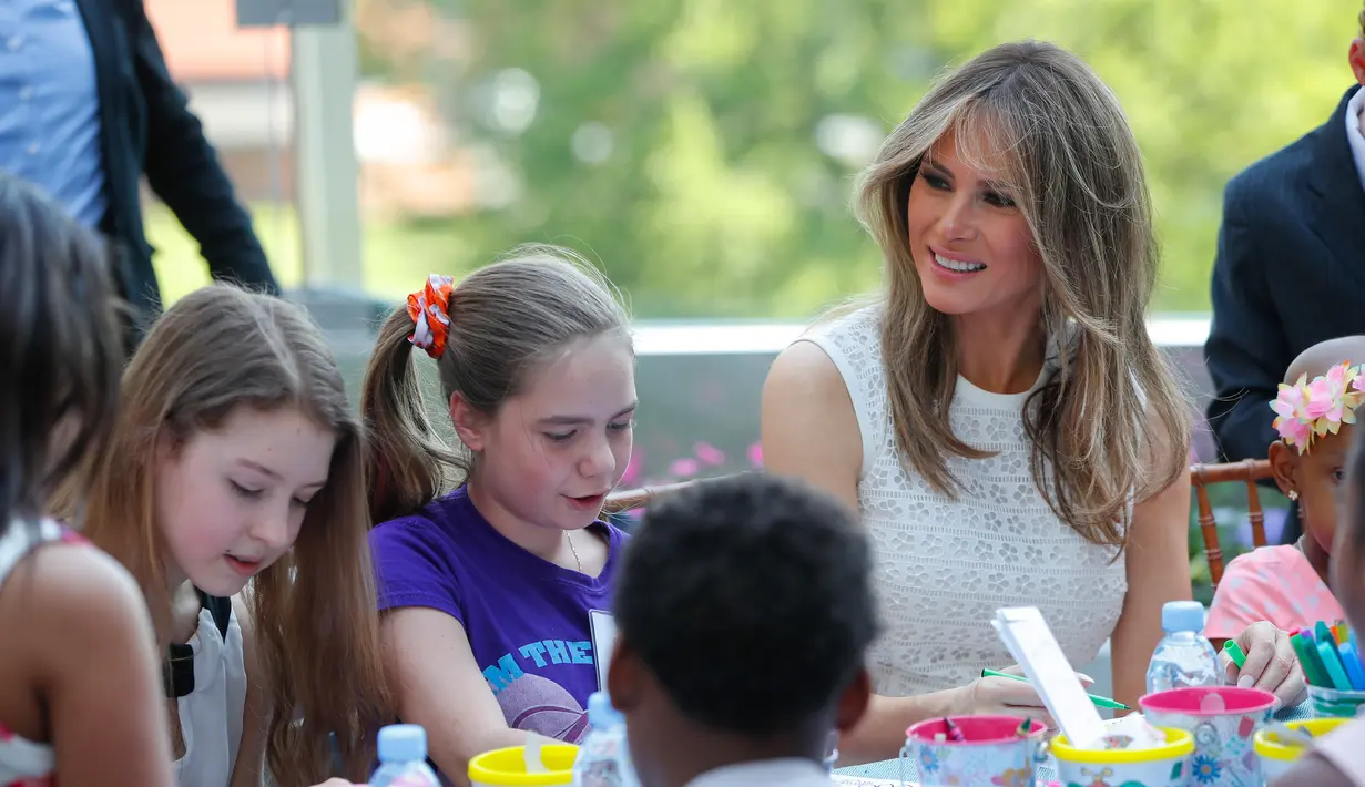 Melania Trump berbincang dengan anak-anak yang sedang mewarnai gambar saat pembukaan Taman Bunny Mellon Healing Garden Bunny Mellon di Rumah Sakit Nasional Anak di Washington, (29/4). (AP Photo/Pablo Martinez Monsivais)