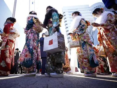 Perempuan Jepang berkimono yang merayakan ulang tahun ke-20 antre memasuki tempat untuk berpartisipasi dalam upacara resmi, yang biasa disebut upacara Kedewasaan di Yokohama dekat Tokyo, Senin (9/1/2023). Diadakan setiap tahun pada hari Senin kedua di bulan Januari, pemerintah kota setempat merayakan Hari Kedewasaan atau Seiji no Hi. (AP Photo/Eugene Hoshiko)