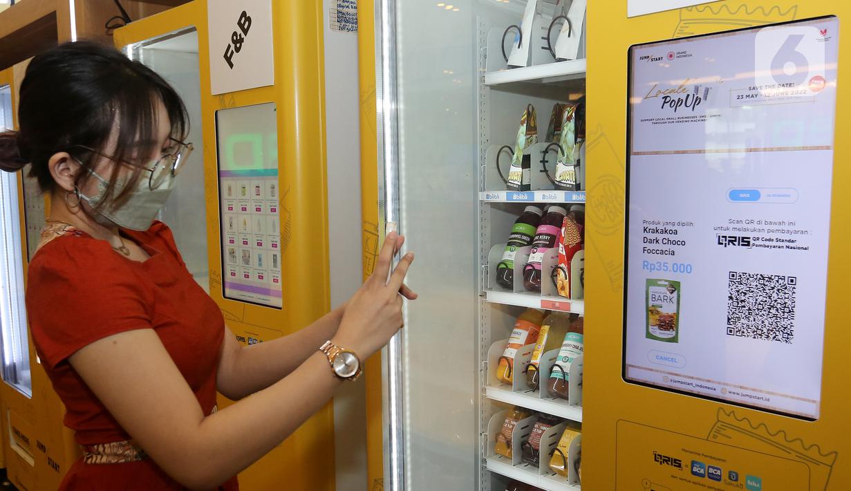 Pengunjung membeli minuman dengan QRIS pada Smart Vending Machine di East Mall Grand Indonesia, Jakarta, Selasa (24/05/2022). Blibli dan Jumpstart berkolaborasi meluncurkan vending machine pertama di Indonesia yang menawarkan ragam produk UMKM terbaik binaan Blibli di bawah GDP Ventures. (Liputan6.com/Fery Pradolo)