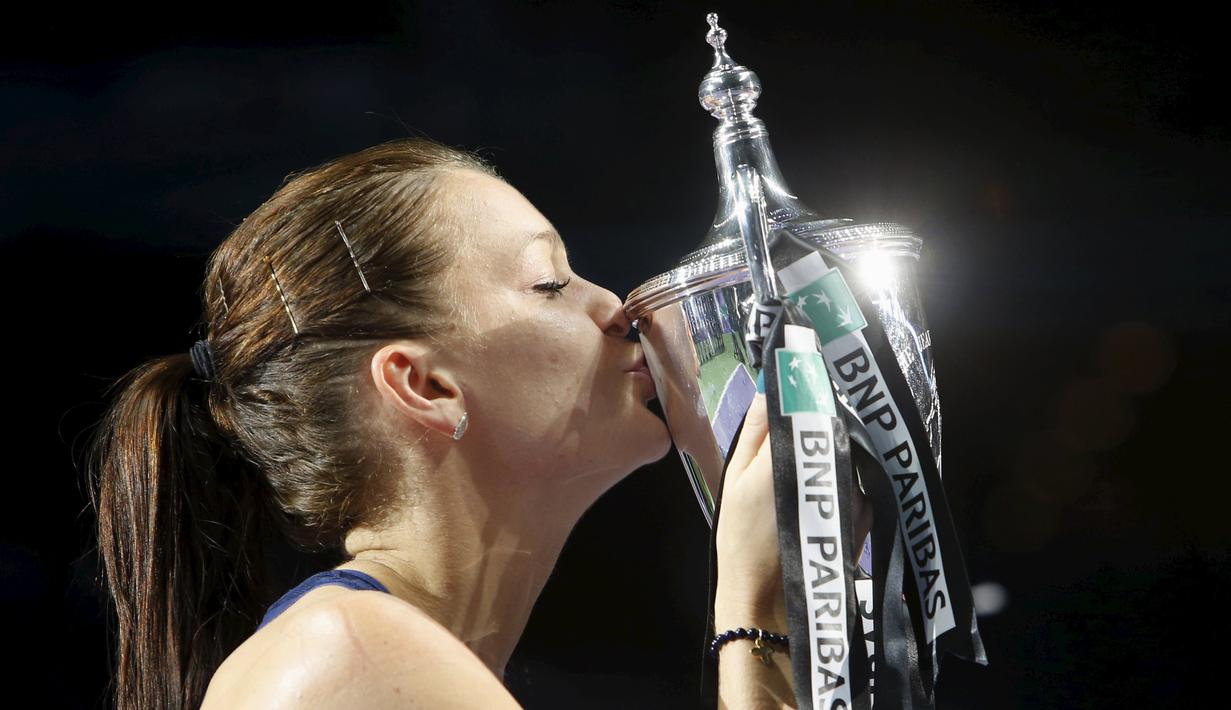 Petenis putri Polandia, Agnieszka Radwanska, mencium trofi WTA Finals setelah mengalahkan Petra Kvitova dari Republik Ceska dalam final di Singapore Indoor Stadium, Minggu (1/11/2015). (Reuters/Edgar Su)