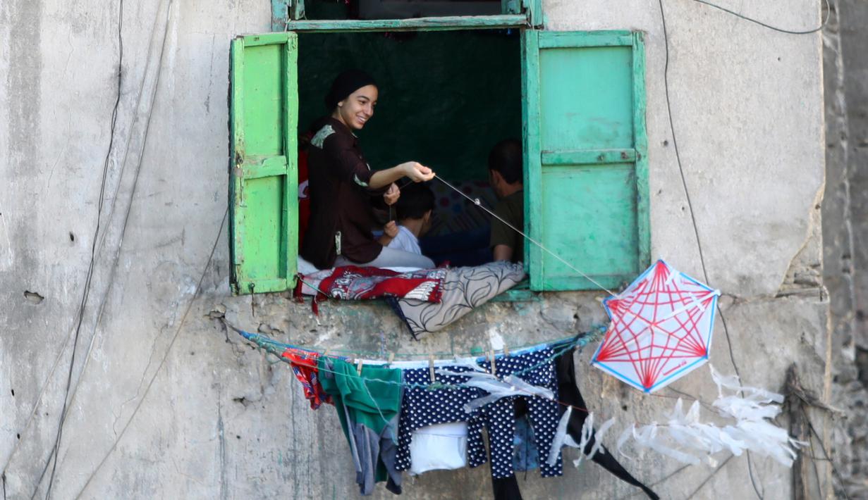 Seorang perempuan menerbangkan layang-layang dari rumah selama masa pandemi COVID-19 di Kairo, Mesir, pada Senin (11/5/2020). Mesir mencatatkan peningkatan harian sebanyak 346 kasus infeksi COVID-19, menambah jumlah kasus terkonfirmasi di negara itu menjadi 9.746. (Xinhua/Ahmed Gomaa)