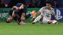 Pemain PSG, Achraf Hakimi (kiri) mengeram kesakitan setelah dijegal pemain Bayern Munchen, Luis Diaz dalam laga Liga Champions 2025/2026 di Parc des Princes, Paris, Prancis, Selasa (04/11/2025) waktu setempat. (AFP/Franck Fife)
