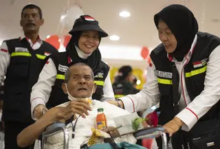 Petugas PPIH Arab Saudi Daker Makkah melayani jemaah haji lanjut usia (lansia) saat hendak umrah. (FOTO: MCH PPIH ARAB SAUDI 2023)