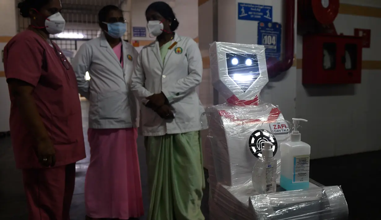 Staf medis berpartisipasi dalam demo robot interaktif 'Zafi' di rumah sakit Stanley Medical di Chennai, 6 April 2020. Rumah sakit ini mengerahkan robot untuk melayani makanan dan obat-obatan bagi pasien Covid-19 dalam upaya meminimalkan tenaga medis tertular virus corona. (Arun SANKAR/AFP)