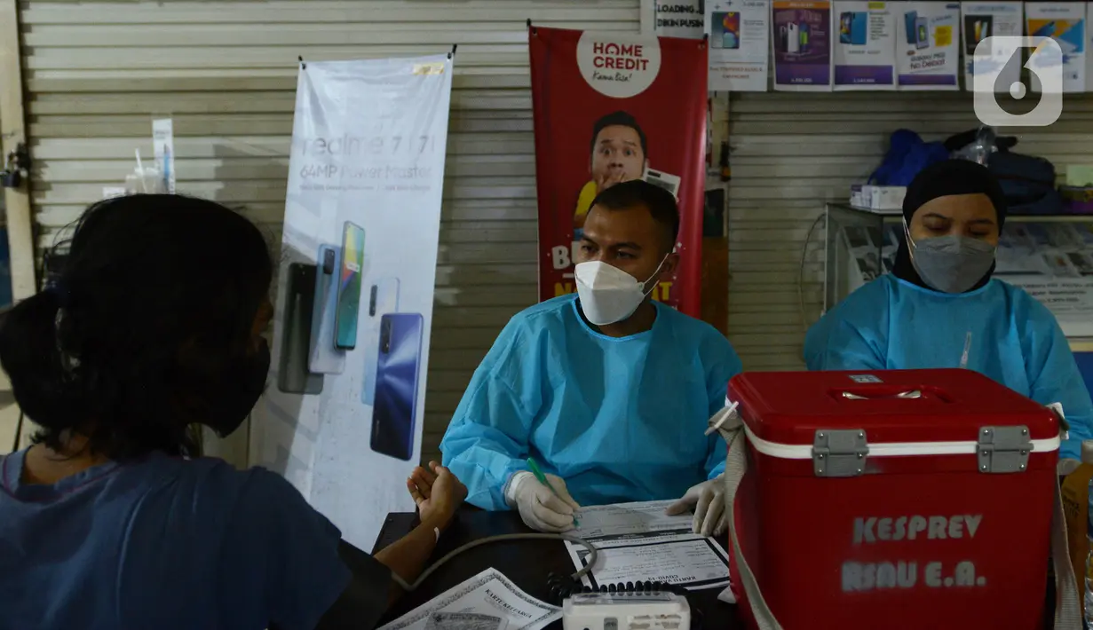 Warga menjalani pemeriksaan saat mengikuti vaksinasi COVID-19 di Plaza Pondok Gede, Bekasi, Jawa Barat, Selasa (27/7/2021). Vaksinasi yang digelar TNI AU bersama Pemkot Bekasi ini berlangsung selama dua hari dengan menargetkan 5.000 warga Bekasi dan sekitarnya. (merdeka.com/Imam Buhori)
