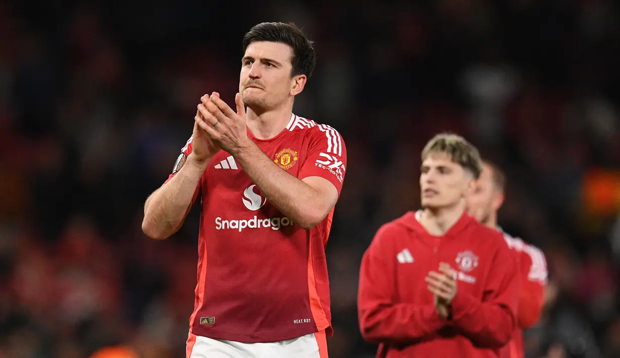 Pemain Manchester United, Harry Maguire merayakan kemenangan atas Lyon dalam laga leg 2 perempat final Liga Europa 2024/2025 di Old Trafford, Manchester, Inggris, Jumat (18/04/2025) WIB. (AFP/Oli Scarff)