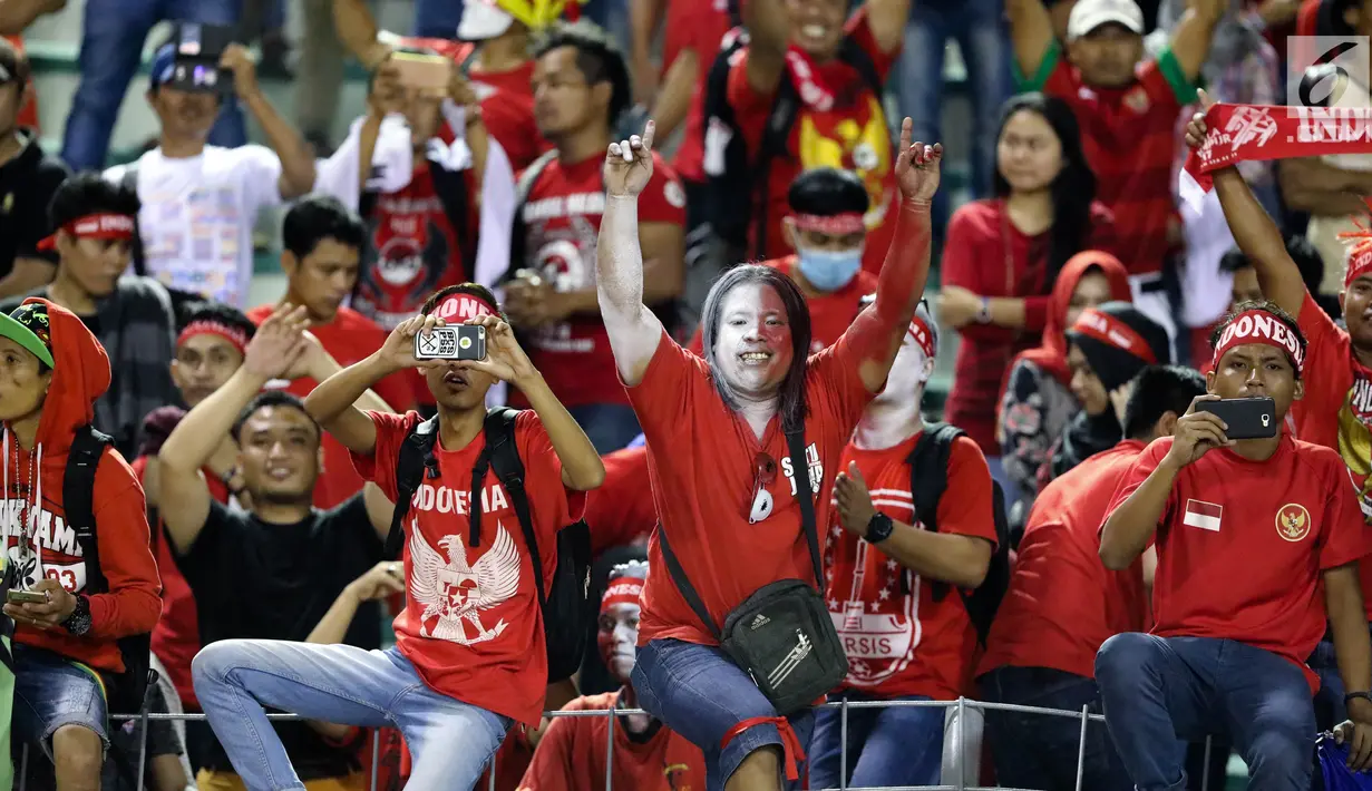 Seorang suporter timnas Indonesia U-22 mengecat wajahnya saat menyaksikan laga penyisihan Grup B melawan Vietnam di Stadion Selayang, Selangor, Selasa (22/8). Indonesia bermain imbang melawan Vietnam dengan skor 0-0. (Liputan6.com/Faizal Fanani)