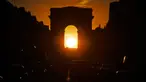 Foto yang diambil pada 2 Agustus 2022 menunjukkan Arc de Triomphe saat matahari terbenam, di Paris. Peristiwa yang dikenal sebagai "Paris Henge" ini terjadi dua kali setahun. (Photo by Stefano RELLANDINI / AFP)