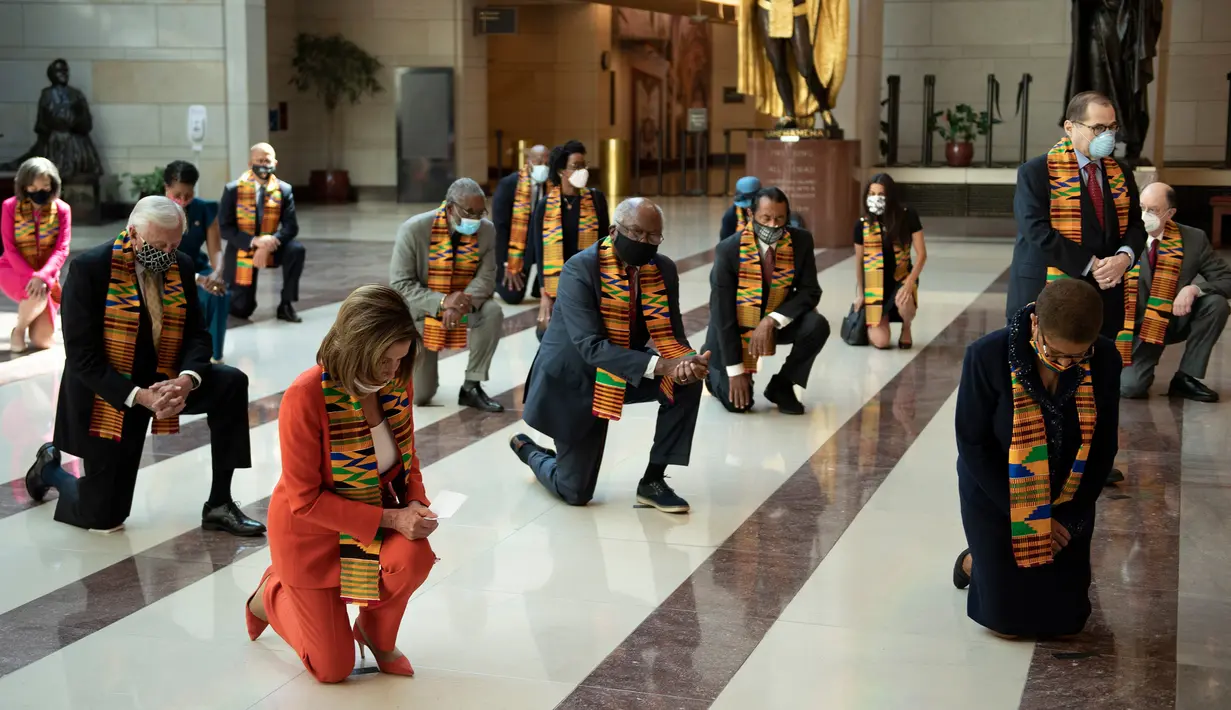 Ketua DPR Nancy Pelosi bersama anggota Kongres AS dari Fraksi Demokrat berlutut dan mengheningkan cipta di Gedung Kongres AS, Senin (8/5/2020). Mereka berlutut selama 8 menit 46 detik, atau selama waktu yang sama saat Derek Chauvin menginjak leher George Floyd. (Chip Somodevilla/Getty Images/AFP)