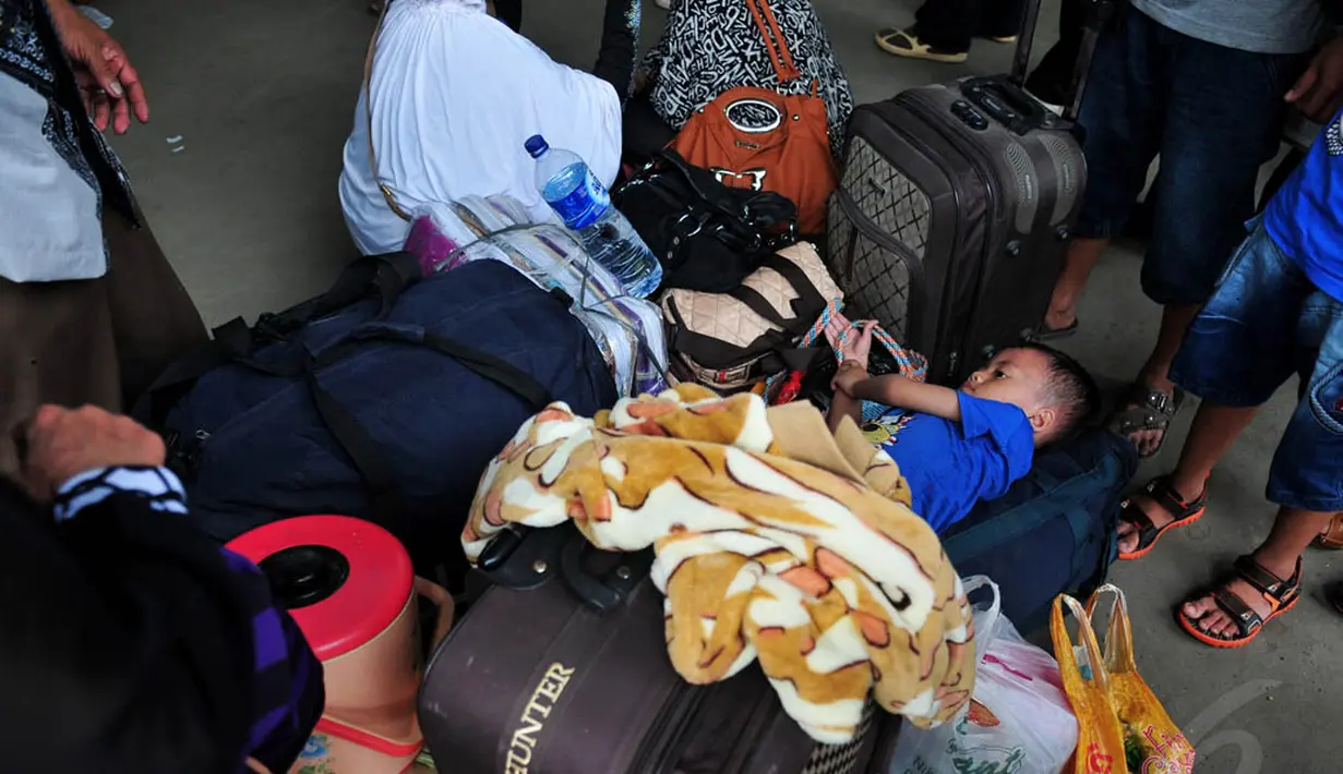 Seorang anak terlihat berbaring di aats tumpukan tas besar di Stasiun Senen, Jakarta, Jumat (18/7/14). (Liputan6.com/Johan Tallo)
