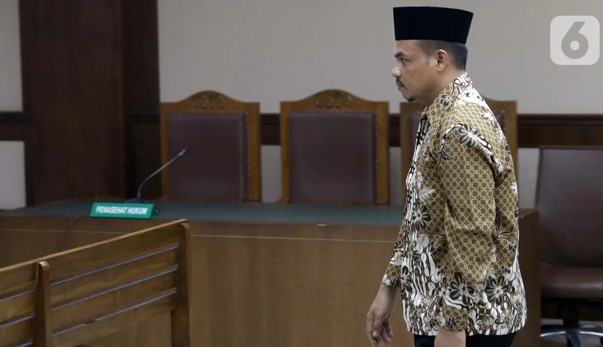 Tersangka dugaan suap ke Gubernur Kepri nonaktif Nurdin Basirun, Abu Bakar bersiap menjalani sidang pembacaan dakwaan di Pengadilan Tipikor, Jakarta, Rabu (2/10/2019). Abu Bakar didakwa membantu pengusaha Kock Meng memberikan suap terkait izin pemanfaatan laut. (Liputan6.com/Helmi Fithriansyah)