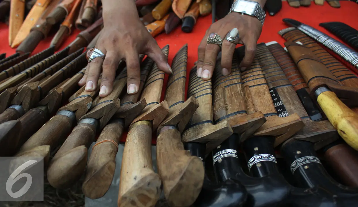 Pedagang golok mentata barang dagangannya dalam rangka Lebaran Betawi di Lapangan Banteng, Jakarta (22/08/15). Golok/Bendo adalah senjata Tradisonal suku Betawi. (Liputan6.com/Gempur M Surya)