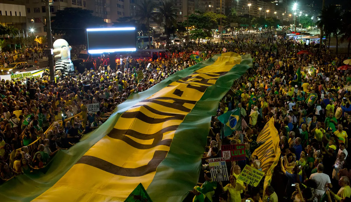 Demonstran membentangkan spanduk dalam warna bendera Brasil yang bertuliskan dalam bahasa Portugis "Cuci Mobil" saat menggelar aksi protes di Rio de Janeiro, Brasil (3/4). (AP / Silvia Izquierdo)