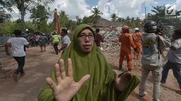 Seorang wanita berlari mencari tempat perlindungan saat terjadi gempa susulan di Tanjung pulau Lombok, NTB, Kamis (9/8). Menurut BNPB pusat gempa berada di enam kilometer barat laut Lombok Utara dengan kedalaman 12 kilometer. (AFP/ ADEK BERRY)