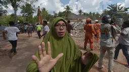 Seorang wanita berlari mencari tempat perlindungan saat terjadi gempa susulan di Tanjung pulau Lombok, NTB, Kamis (9/8). Menurut BNPB pusat gempa berada di enam kilometer barat laut Lombok Utara dengan kedalaman 12 kilometer. (AFP/ ADEK BERRY)