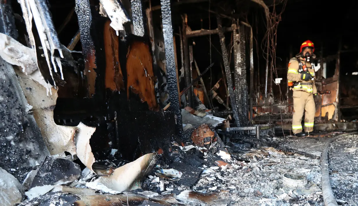 Petugas pemadam kebakaran memeriksa kondisi rumah sakit Sejong di Milyang, Korea Selatan, yang hangus terbakar,  Jumat (26/1). Api diduga dipicu oleh sebuah kecelakaan dan ruang gawat darurat di lantai satu rumah sakit. (Kim Dong-mi/Yonhap via AP)