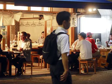 Orang-orang menikmati minuman di sebuah bar di Tokyo, Jepang, 4 Oktober 2021. Warga kembali beraktivitas setelah berakhirnya status pembatasan darurat virus corona COVID-19 di Jepang. (AP Photo/Koji Sasahara)