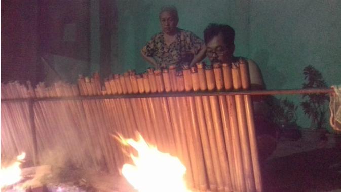Keluarga Pricilia tengah menyiapkan nasi bambu. (Liputan6.com/Heri Susanto)