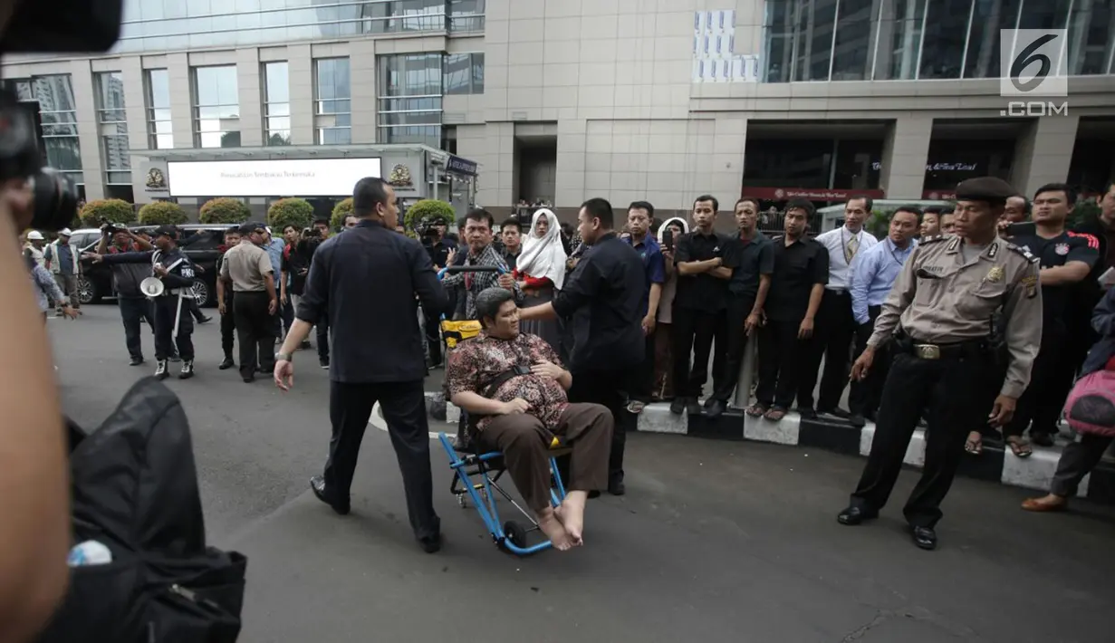 Seorang pria korban ambruknya balkon BEI duduk dikursi roda saat dievakuasi petugas medis di Jakarta, Senin (15/1). Puluhan korban dievakuasi ke rumah sakit terdekat, yaitu RS Siloam dan RS Mintoharjo. (Liputan6.com/Arya Manggala)