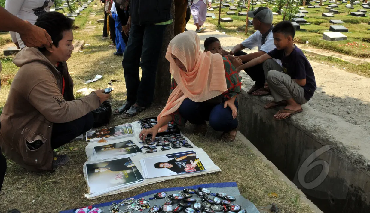 Seorang calon pembeli melihat barang dagangan yang menjual berbagai macam pernak-pernik Olga Syahputra di TPU Malaka, Jakarta, Selasa (31/3/2015). (Liputan6.com/Panji Diksana) 