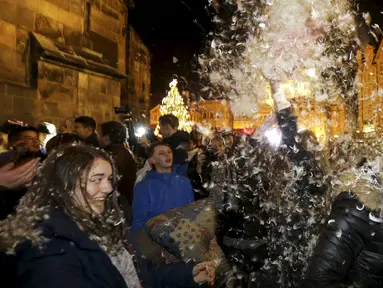 Warga saat melakukan flash mob perang bantal selama empat menit di Old Town Square di Praha,Ceko (22/12). flash mob perang bantal ini dilakukan jelang pergantian akhir tahun. (REUTERS/ David W Cerny)