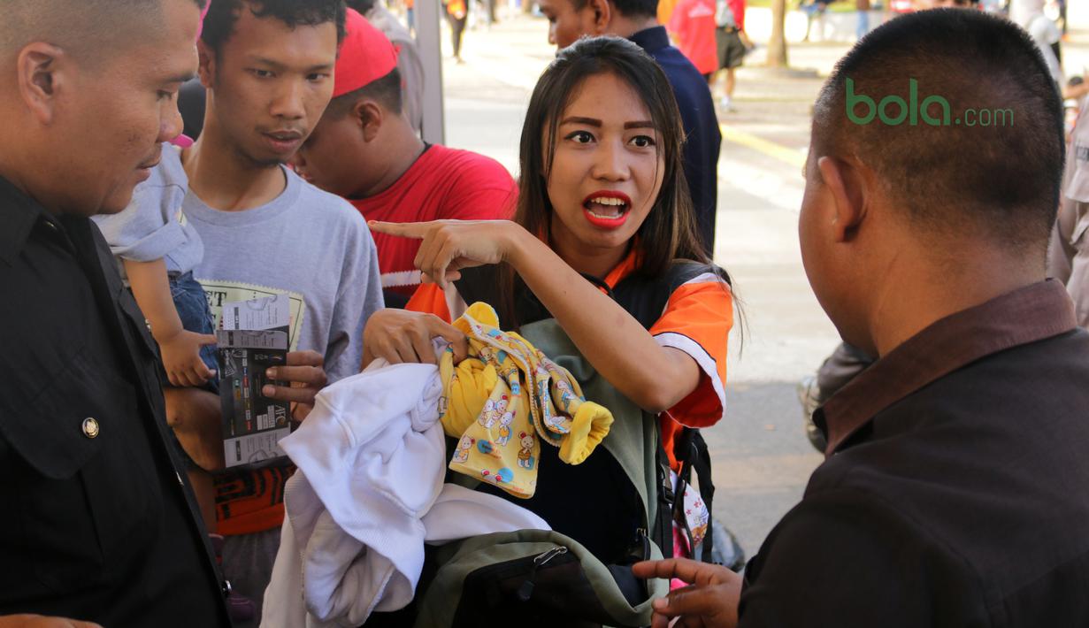 Keluarga suporter mengikuti pemeriksaan sebelum laga Piala AFC 2018 antara Persija Jakarta vs Song Lam Nghe An di Stadion Utama GBK, Rabu (14/3/2018). Panpel menjual sekitar 65.000 lembar tiket. (Bola.com/Surya Bima Mahendarta)