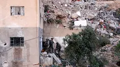 Tentara berjaga di sekitar rumah pejuang Hamas Mohammad Al-Fakih yang ditembak mati oleh pasukan Israel di desa Tepi Barat Surif, dekat Hebron, (27/7). (REUTERS/Mussa Qawasma)