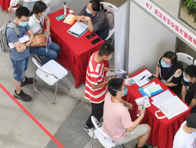 Pencari kerja melakukan wawancara dengan sejumlah perusahaan dalam bursa kerja yang digelar di Universitas Jianghan di Wuhan, Hubei, 1 Juni 2020. Lebih dari 80 perusahaan berpartisipasi dalam bursa kerja luring pertama bagi para lulusan setelah pandemi covid-19 mereda di Wuhan. (Xinhua/Cheng Min)