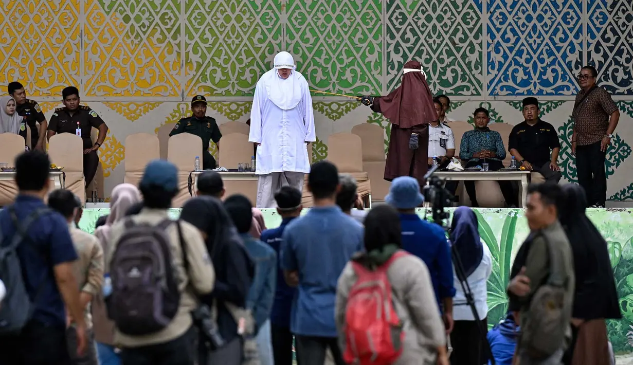 Seorang wanita menjalani hukuman cambuk setelah dinyatakan bersalah melanggar hukum syariat Islam Aceh yang melarang hubungan seksual di luar nikah di Banda Aceh,  Kamis, 20 Agustus 2026. (AFP/ Chaideer Mahyuddin)