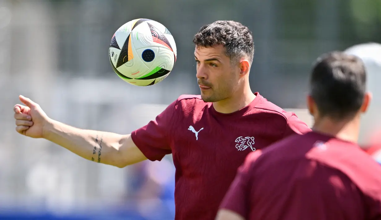 Gelandang Swiss #10 Granit Xhaka mengontrol bola selama sesi latihan MD-1 menjelang laga Grup A UEFA Euro 2024 di Robert-Schlienz-Stadion, Stuttgart, Selasa (18/6/2024). (Fabrice COFFRINI / AFP)