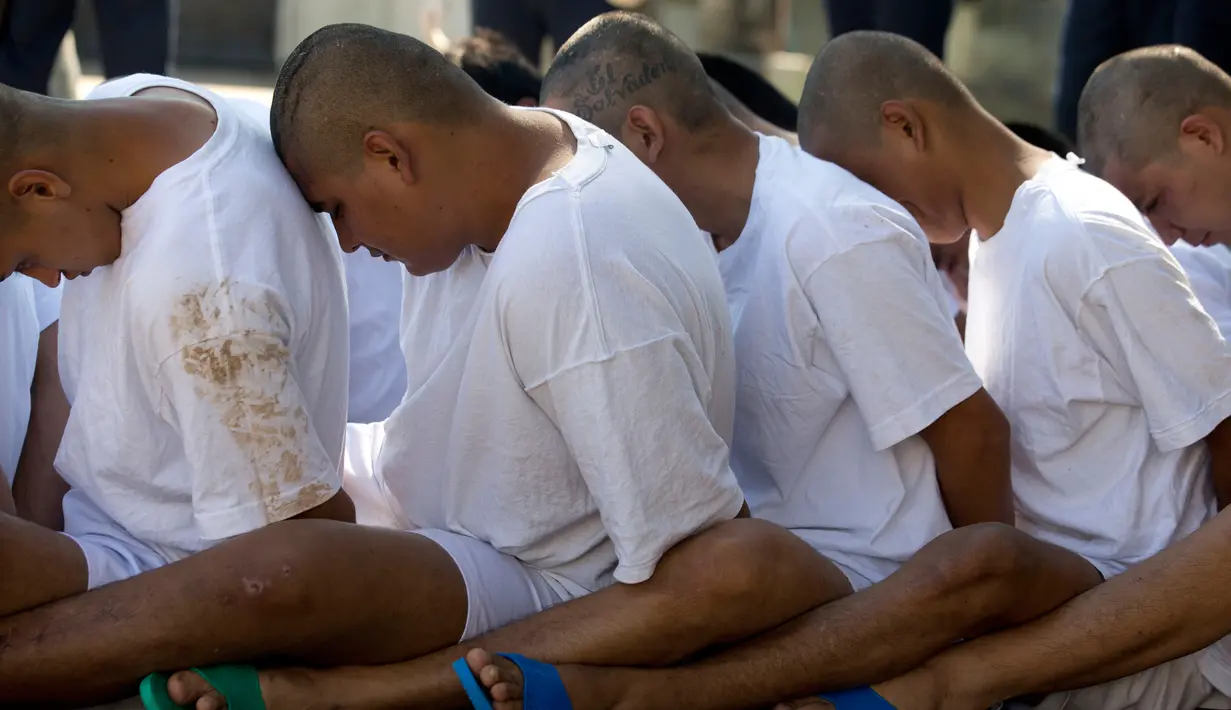 Anggota geng Mara Salvatrucha (MS-13) duduk berbaris di penjara dengan keamanan maksimal di Zacatecoluca, El Salvador (31/1). Menurut data FBI, jumlah anggota geng Mara Salvatrucha sejak 2005 mencapai angka lima ribu orang. (AP Photo/Moises Castillo)