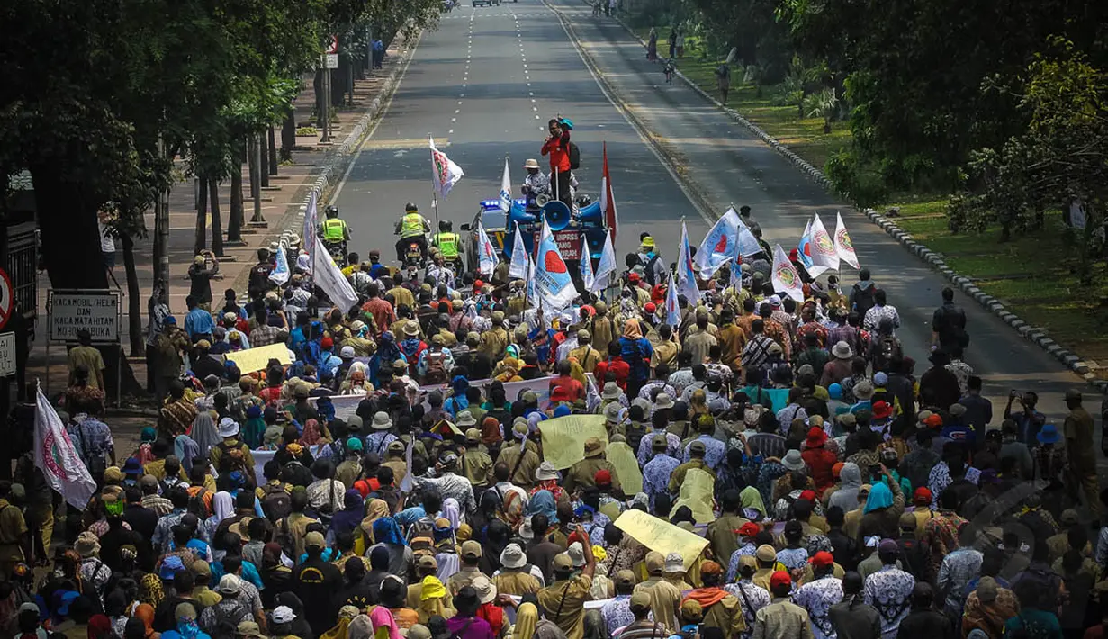 Forum Honorer Kategori 2 (FHK2) saat menggelar aksi longmarch dari patung kuda menuju Istana Negara, Jakarta, (15/10/14). (Liputan6.com/Faizal Fanani) 