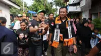Cagub DKI Jakarta, Agus Harimurti Yudhoyono (kanan) berjalan saat sosialisasi di Jalan Menteng Raya, Jakarta, Kamis (22/12). Sebelumnya, Agus berkeliling ke beberapa RW di kawasan Menteng Tenggulun, Jakarta. (Liputan6.com/Helmi Fithriansyah)