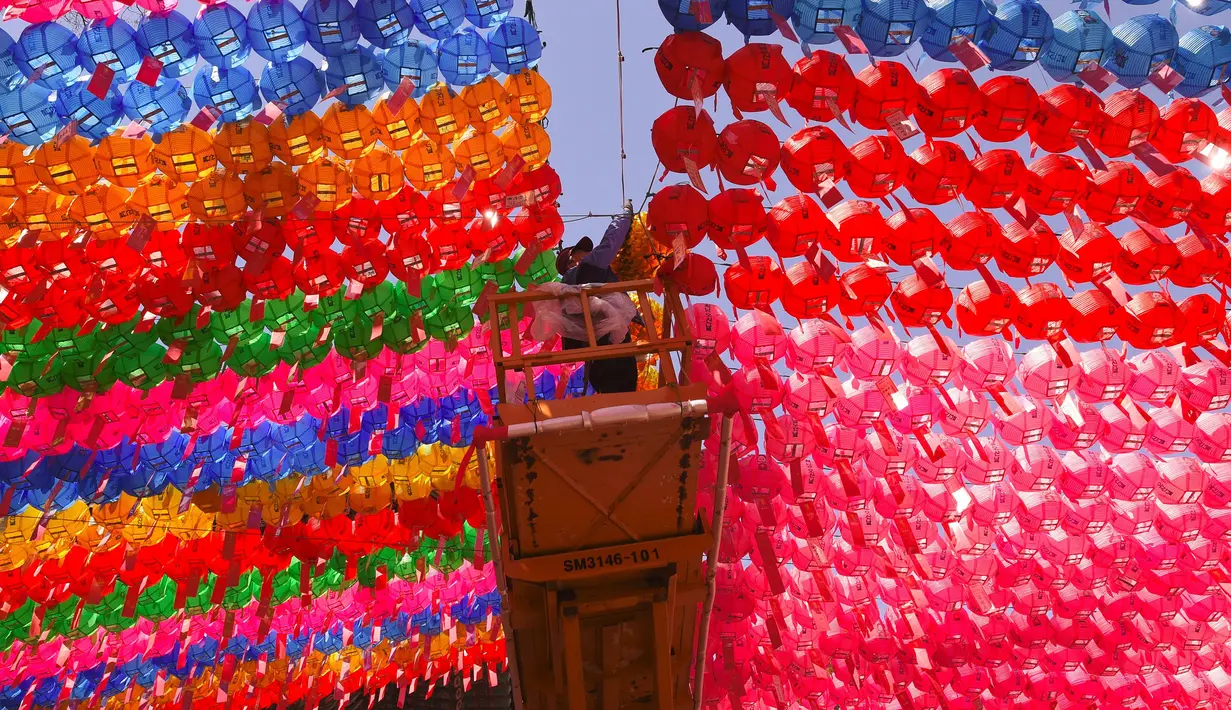 Pekerja memasang lampion di Jogye Temple jelang perayaan ulang tahun Buddha, Seoul, Rabu (12/4). Banyaknya jumlah lampion warna-warni yang terpasang membuat tempat ibadah ini semakin menarik untuk dikunjungi. (AFP PHOTO / JUNG Yeon-Je) 