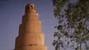 <p>Warga Irak berjalan di menara spiral Malwiya, monumen nasional Irak yang berharga pada pertengahan abad kesembilan, di dalam Kota Arkeologi Samarra, di Samarra, utara Baghdad (26/7/2022). Menara helikoid 50m dari batu bata yang dikeringkan dan dipanggang dengan sinar matahari, mencontoh ziggurat kuno yang dibangun untuk melambangkan kekuatan Islam selama kekhalifahan Abbasiyah, terdaftar sebagai Situs Warisan Dunia UNESCO pada tahun 2007. (AFP/Ismael Adnan)</p>