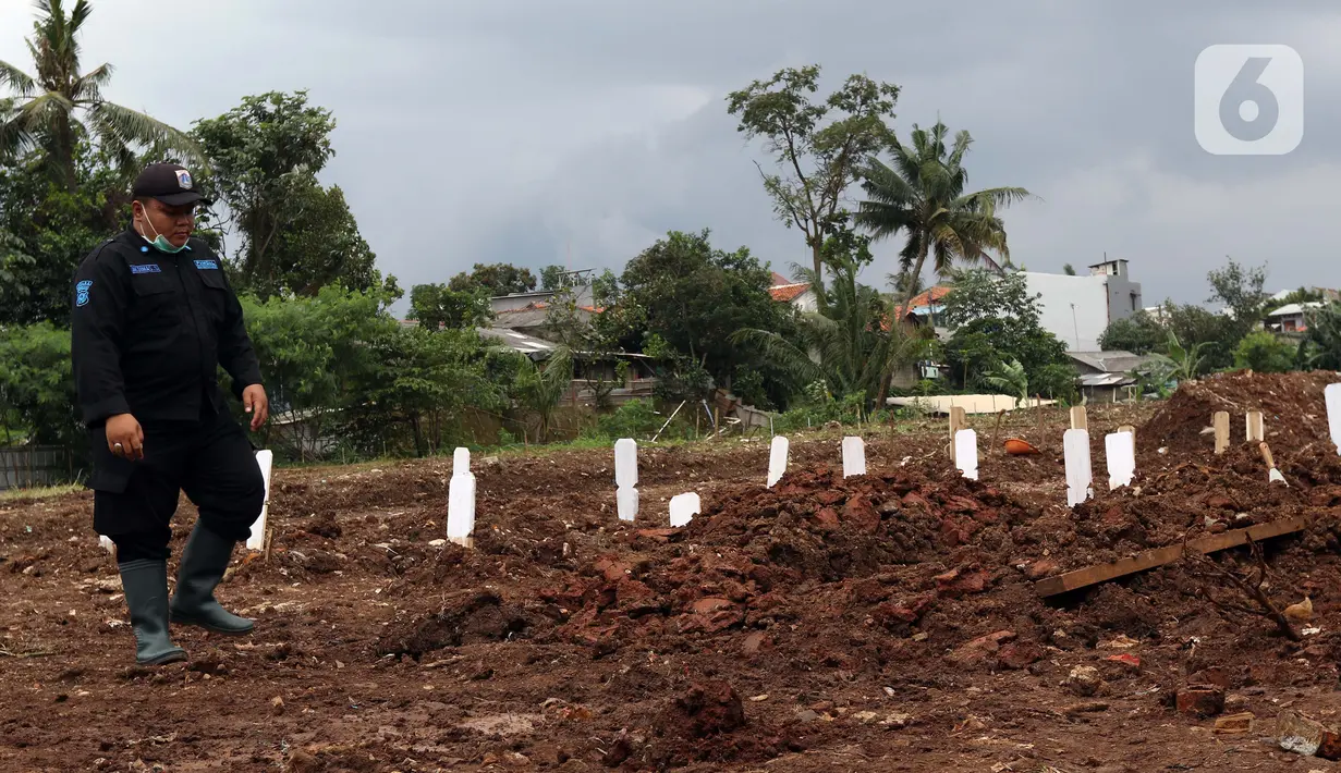 Petugas keamanan memeriksa area khusus pemakaman jenazah dengan protokol COVID-19 di TPU Srengseng Sawah Dua, Jakarta, Selasa, (2/2/2021). TPU Srengseng Sawah 2, saat ini mulai menerima pemakaman jenazah protokol COVID-19 dengan kapasitas 1.020 petak. (Liputan6.com/Helmi Fithriansyah)