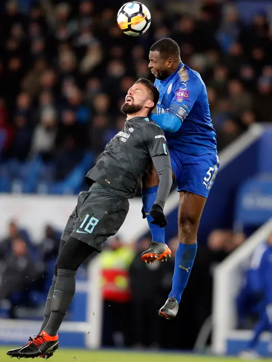 Penyerang Chelsea, Olivier Giroud berebut bola udara dengan bek Leicester City, Wes Morgan saat bertanding pada perempatfinal Piala FA di stadion King Power, Inggris (18/3). Chelsea menang 2-1 atas Leicester. (AP Photo / Frank Augstein)